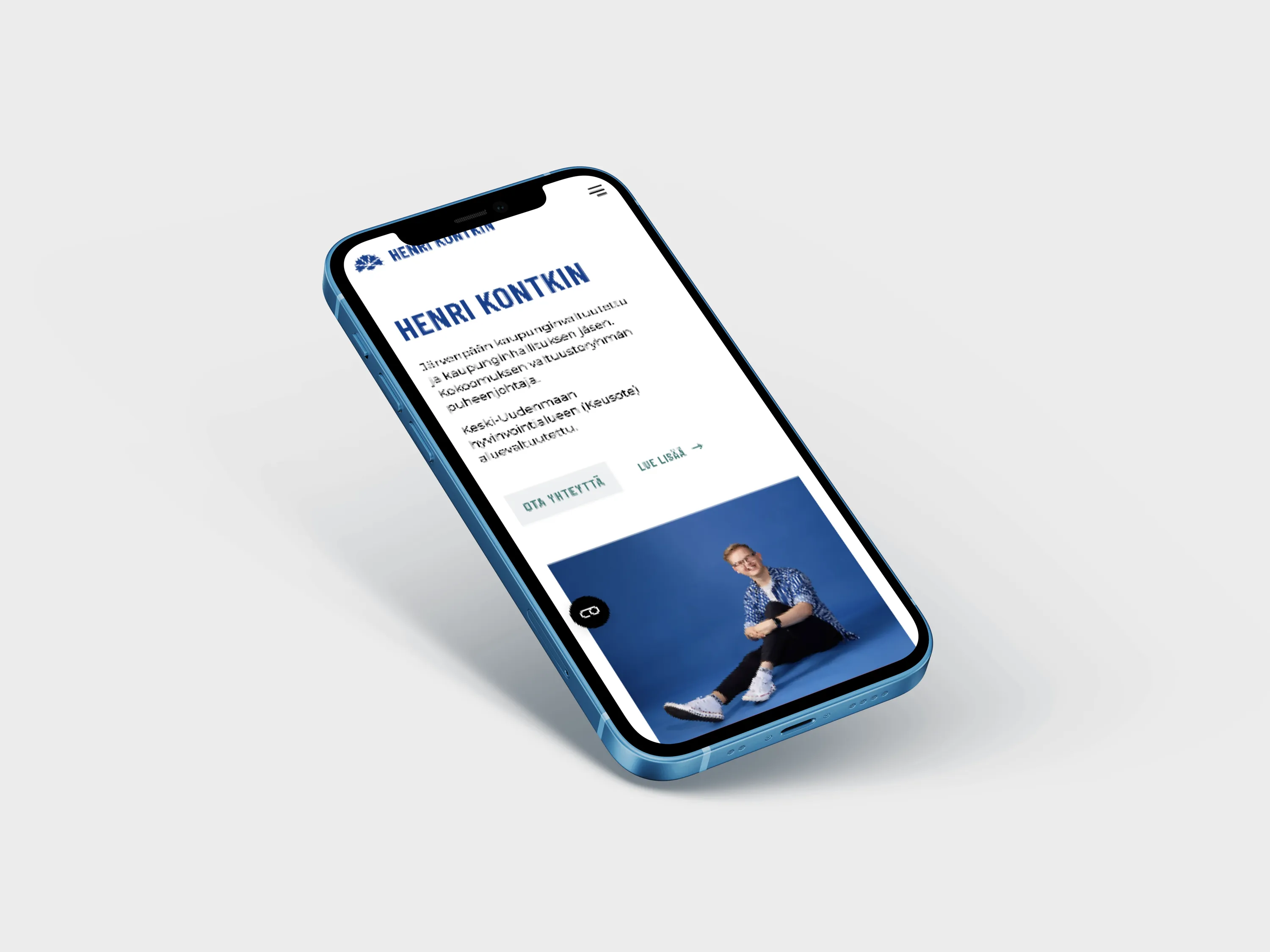 A light blue smartphone displays a website with a man's photo, set against a white background with soft lighting.